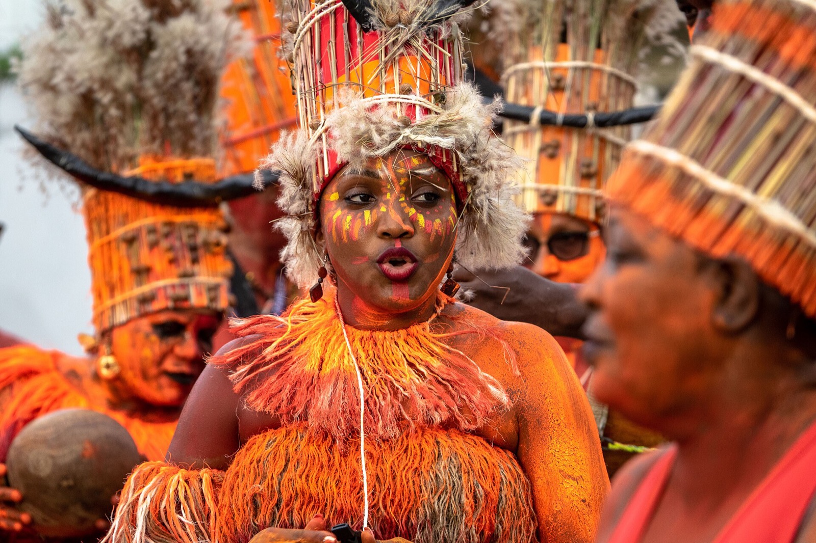 Membres du groupe Ijakata en costumes de raphia orange lors de la grande parade du carnaval de Cayenne